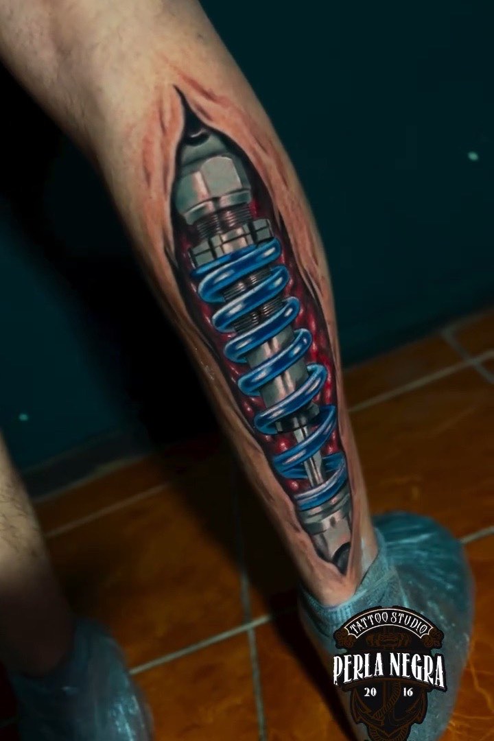 Tatuaje biomecánico: la piel abierta y un amortiguador de metal debajo.