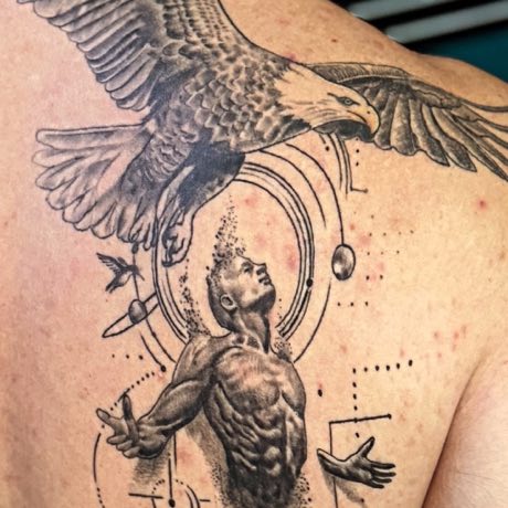 Águila y figura humana en negro y gris, cicatrizados en una espalda.